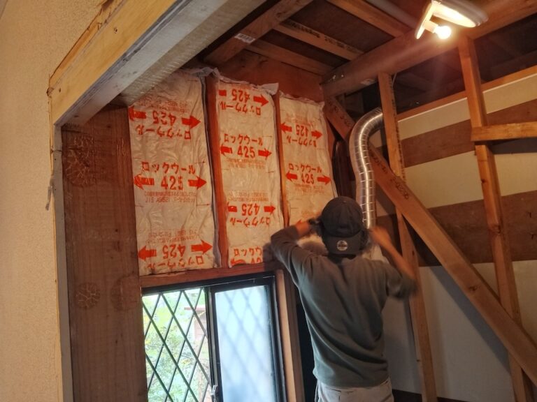 浴室の壁に断熱材を施工する職人